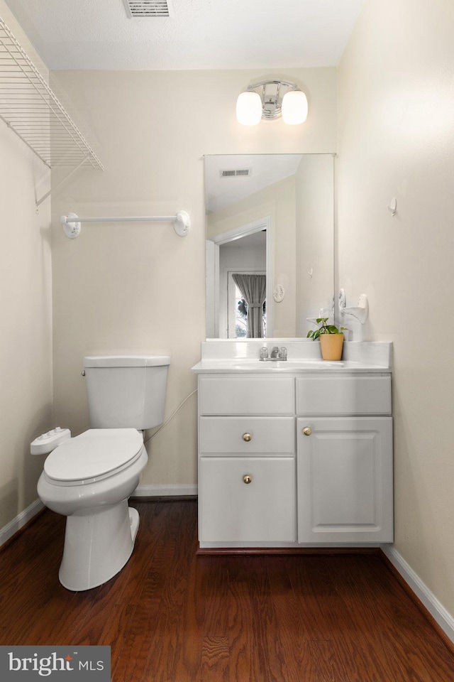 bathroom featuring toilet, wood-type flooring, and vanity