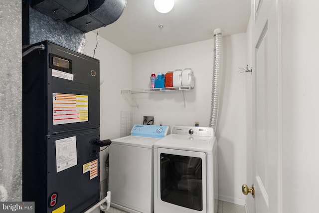 laundry room featuring washer and clothes dryer and heating unit