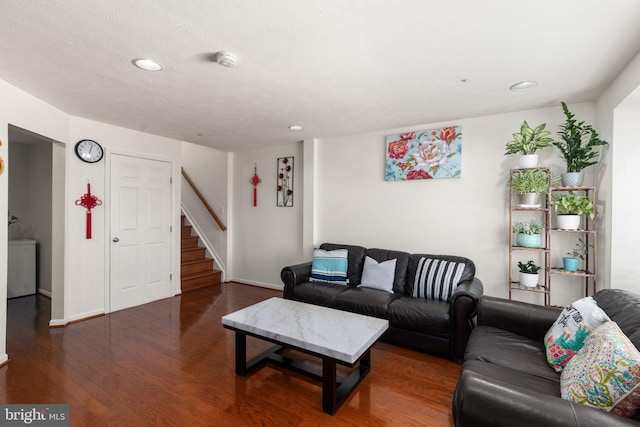 living room with a textured ceiling and dark hardwood / wood-style floors