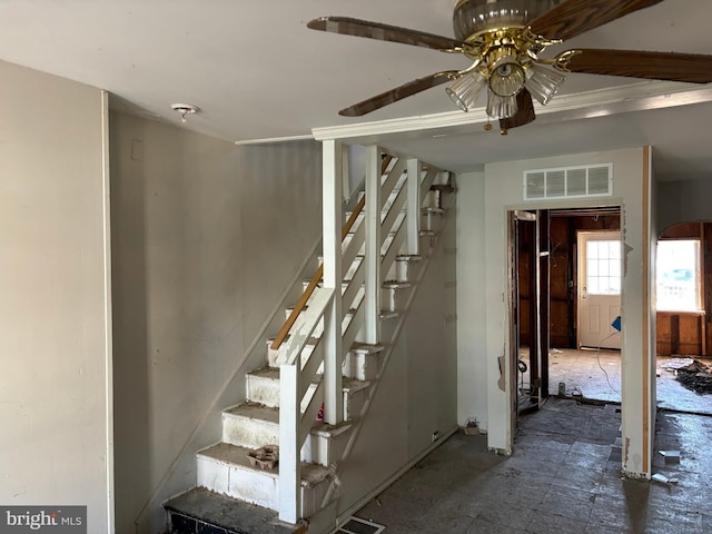 stairway featuring ceiling fan