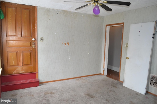 carpeted spare room with ceiling fan