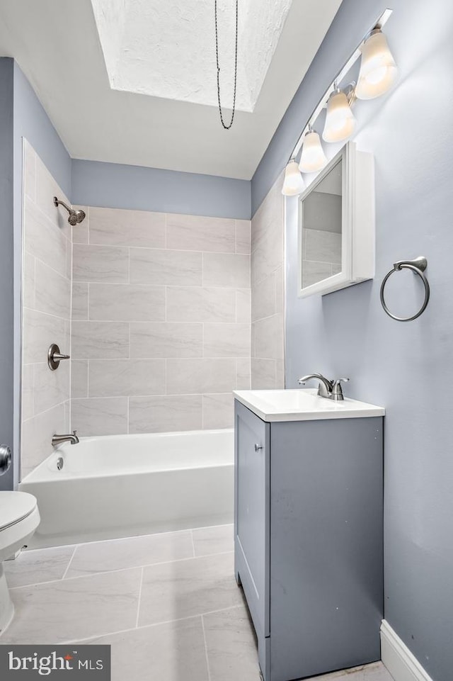 full bathroom featuring vanity, tiled shower / bath combo, and toilet