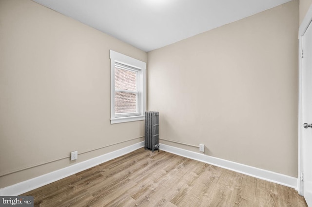 unfurnished room with light wood-type flooring and radiator heating unit