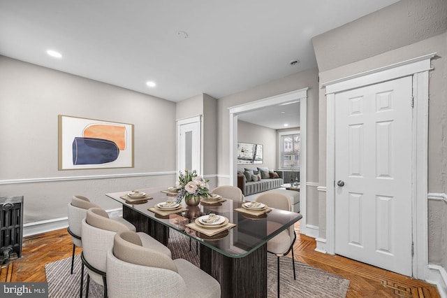 dining space featuring dark parquet flooring