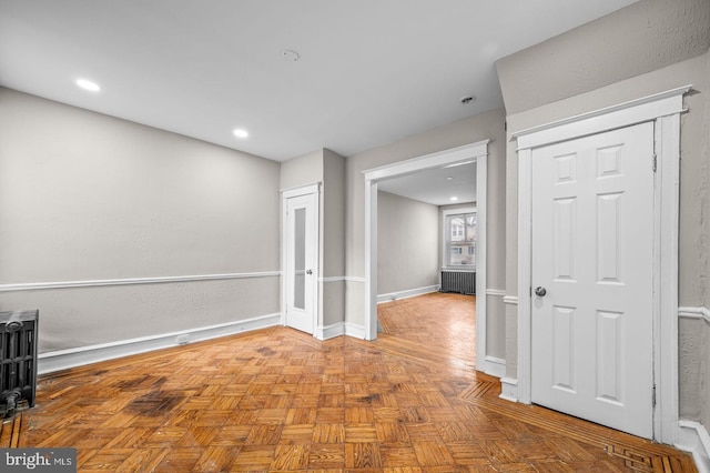 spare room featuring light parquet flooring and radiator heating unit