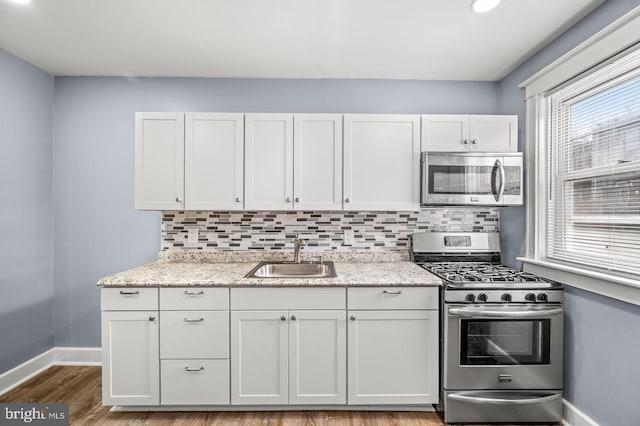 kitchen featuring appliances with stainless steel finishes, white cabinetry, and sink