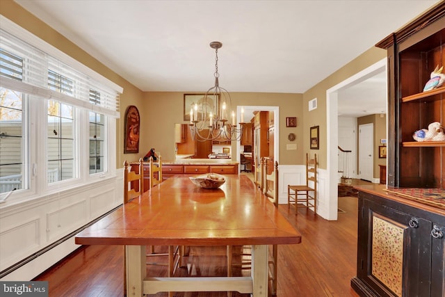 dining room with dark hardwood / wood-style flooring, a baseboard radiator, and a chandelier