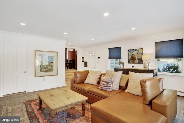 living room with hardwood / wood-style floors, baseboard heating, and ornamental molding