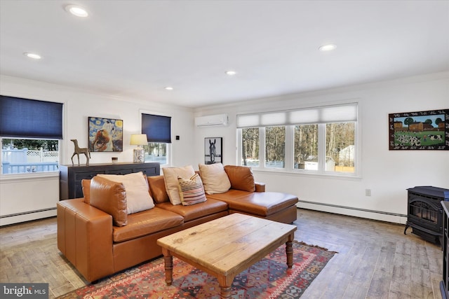 living room with a wood stove, an AC wall unit, crown molding, light wood-type flooring, and baseboard heating