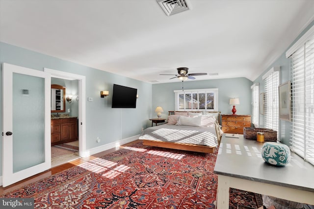 bedroom featuring ensuite bathroom, ceiling fan, and lofted ceiling