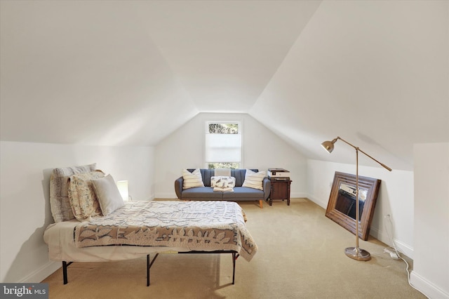 bedroom with light colored carpet and lofted ceiling