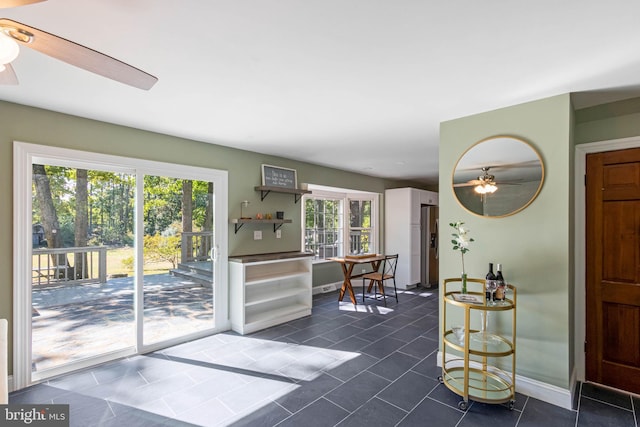 entryway featuring dark tile patterned flooring and ceiling fan