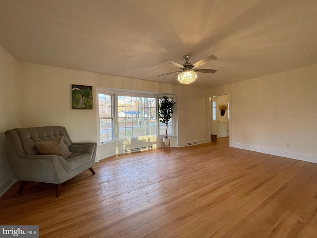 unfurnished room with ceiling fan, light wood-type flooring, and a baseboard radiator