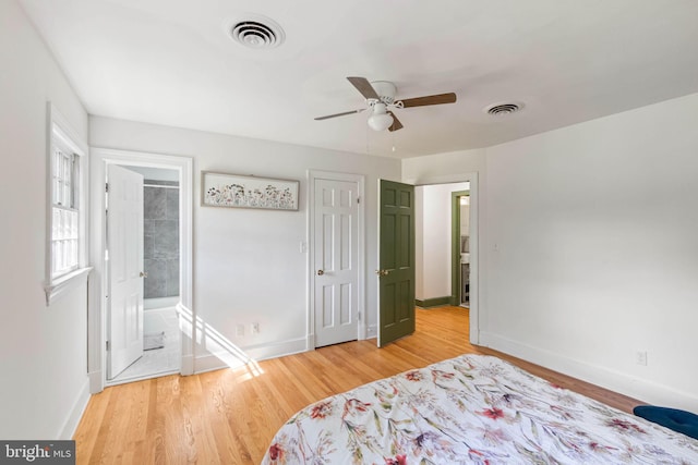 bedroom featuring hardwood / wood-style flooring, ensuite bath, and ceiling fan