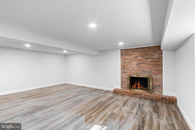 basement featuring a fireplace and light wood-type flooring