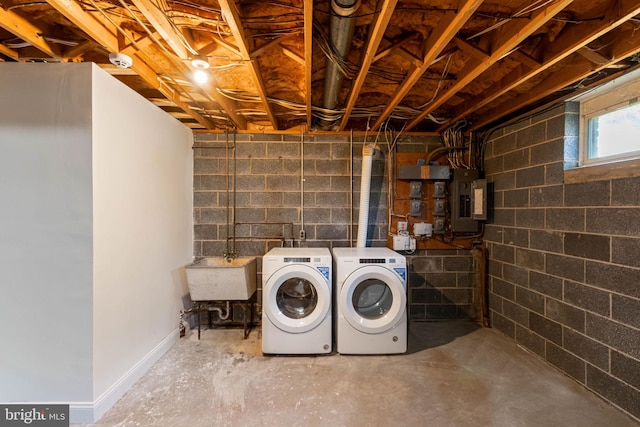 laundry area featuring washer and dryer, electric panel, and sink