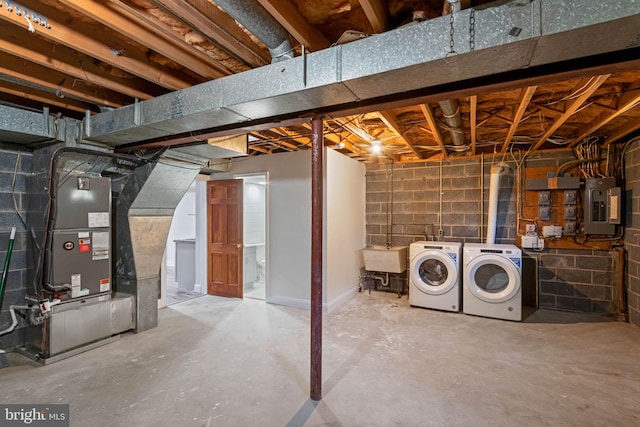 basement with electric panel, separate washer and dryer, sink, and heating unit