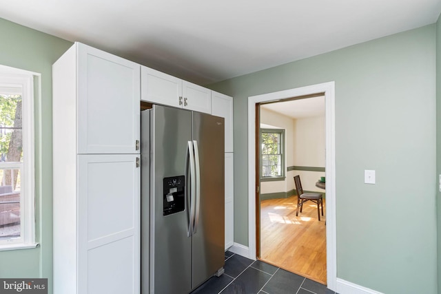 kitchen featuring white cabinetry, stainless steel fridge with ice dispenser, and dark tile patterned floors