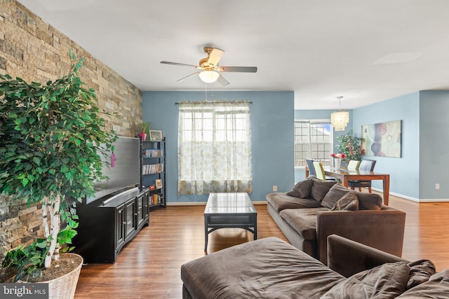 living room with hardwood / wood-style flooring and ceiling fan with notable chandelier