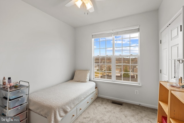 carpeted bedroom with ceiling fan and a closet