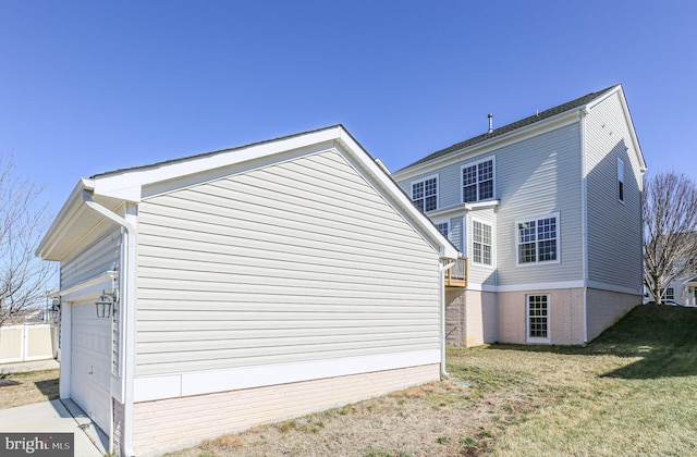 view of side of home with a garage and a lawn