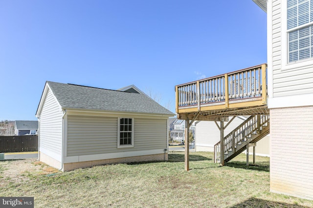 rear view of house featuring a yard and a wooden deck