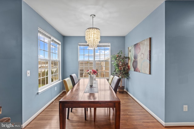 dining area with hardwood / wood-style flooring and a notable chandelier