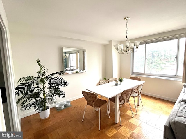 dining room with an inviting chandelier and light parquet floors