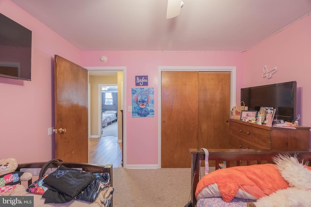 carpeted bedroom with ceiling fan and a closet