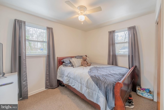 carpeted bedroom with ceiling fan and multiple windows