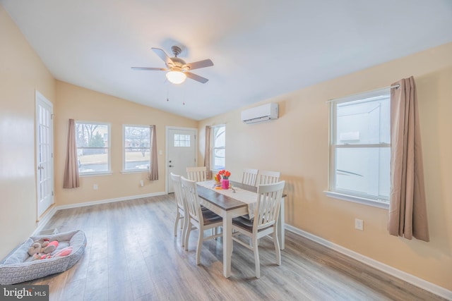 dining room featuring light wood-type flooring, ceiling fan, lofted ceiling, and a wall mounted air conditioner