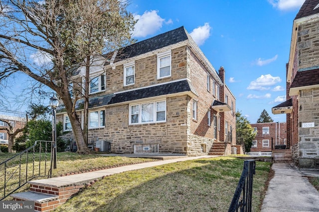 view of front of home featuring central AC unit and a front lawn