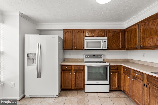 kitchen featuring a textured ceiling, crown molding, light tile patterned floors, and white appliances