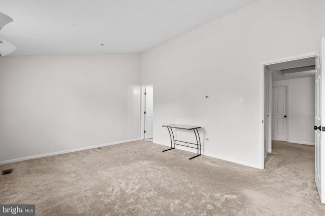 spare room featuring light colored carpet and high vaulted ceiling