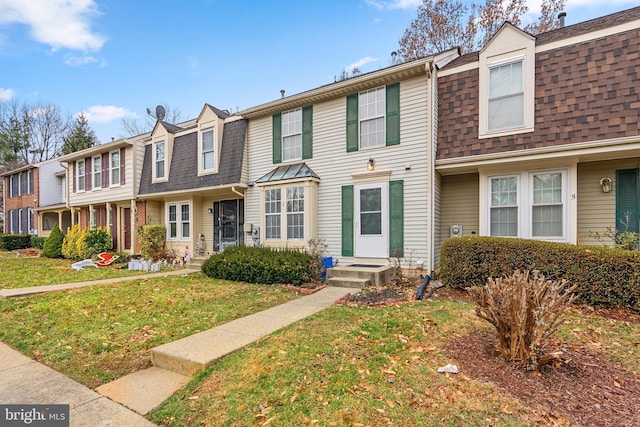 townhome / multi-family property featuring a front lawn