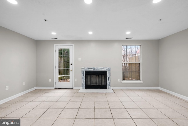 unfurnished living room featuring light tile patterned flooring and a premium fireplace