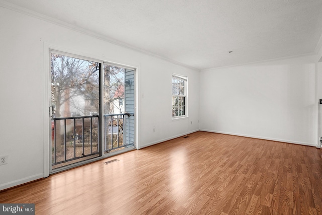 spare room with hardwood / wood-style floors and ornamental molding