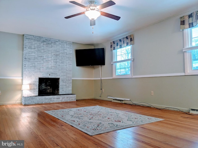 unfurnished living room with ceiling fan, a fireplace, and hardwood / wood-style floors