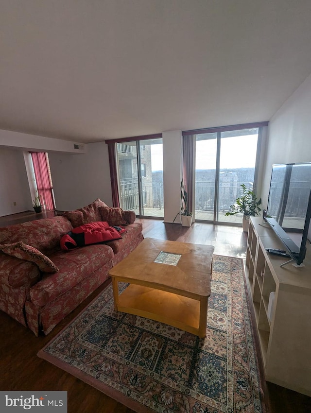 living room with wood-type flooring and a wall of windows