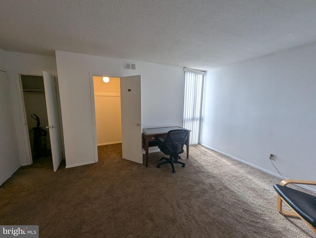 office area with dark colored carpet and a textured ceiling