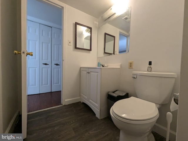 bathroom with hardwood / wood-style floors, vanity, and toilet