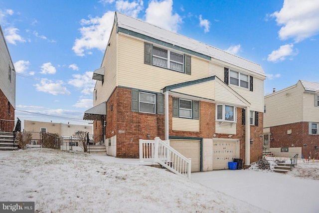 snow covered property with a garage