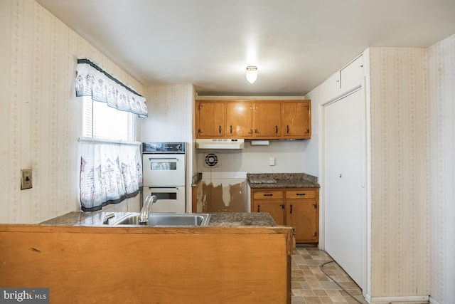 kitchen with kitchen peninsula, sink, and double oven