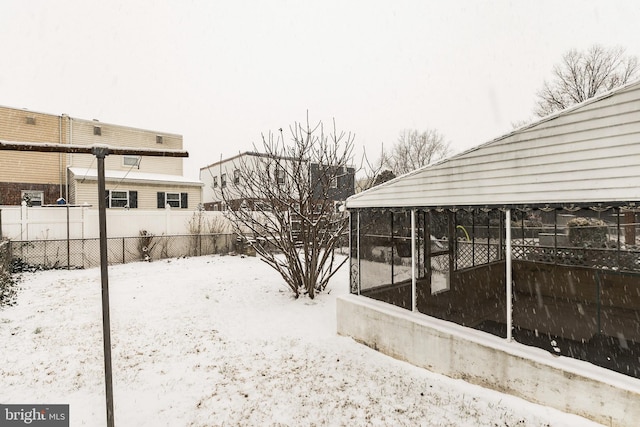 yard covered in snow with a sunroom