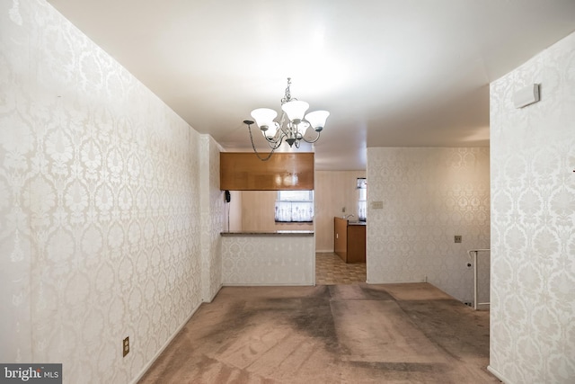 interior space featuring carpet flooring and a chandelier