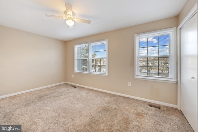 carpeted spare room with ceiling fan