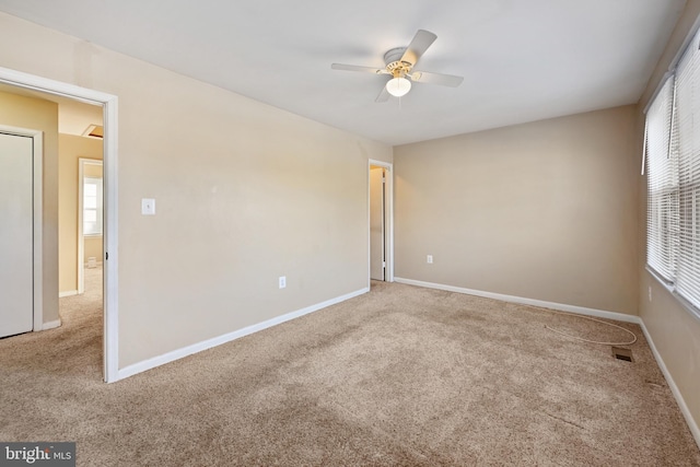 carpeted spare room with a wealth of natural light and ceiling fan