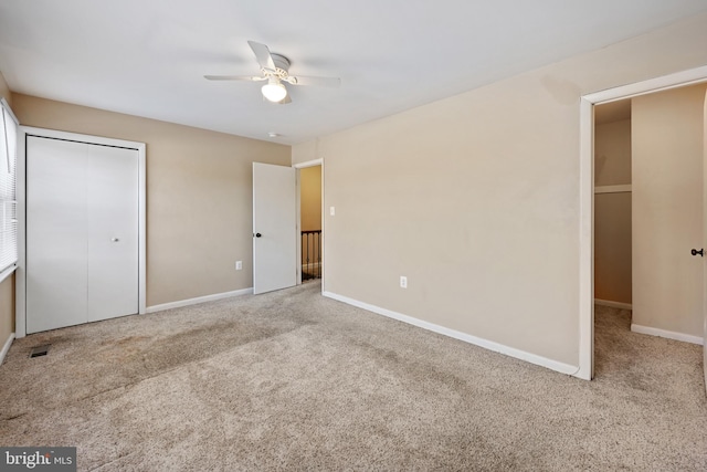 unfurnished bedroom featuring ceiling fan, a closet, and light colored carpet