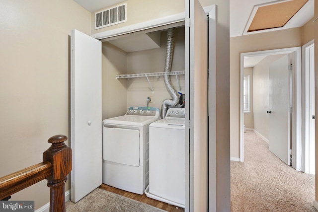 laundry area featuring washer and clothes dryer and light carpet