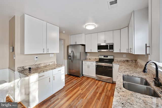 kitchen featuring light hardwood / wood-style flooring, stainless steel appliances, white cabinetry, and sink